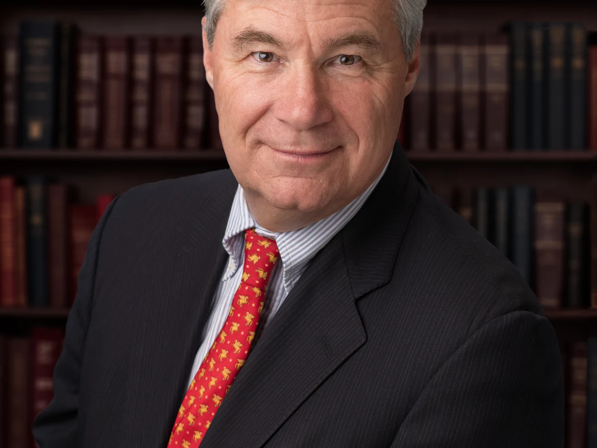 Official portrait of Senator Sheldon Whitehouse in a dark suit against a neutral background.