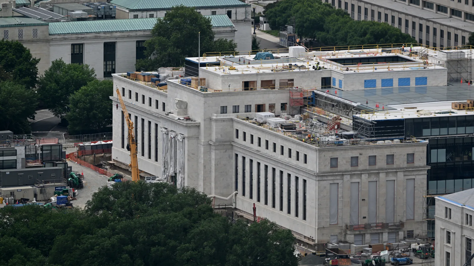 Scaffolding and construction equipment surround the Federal Reserve's stone headquarters in Washington.